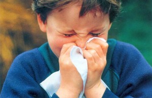 boy with cold blowing his nose