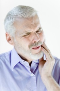 man with toothache holding mouth