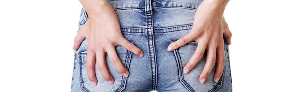 holding bum Girl in jeans holding bottom - possible hemorrhoids