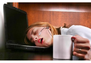 tired woman with head down on her desk