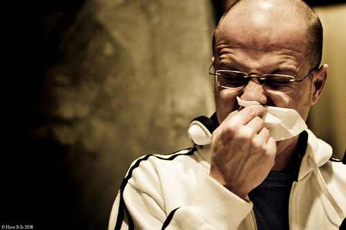 man blows nose man with runny nose blows in hankerchief